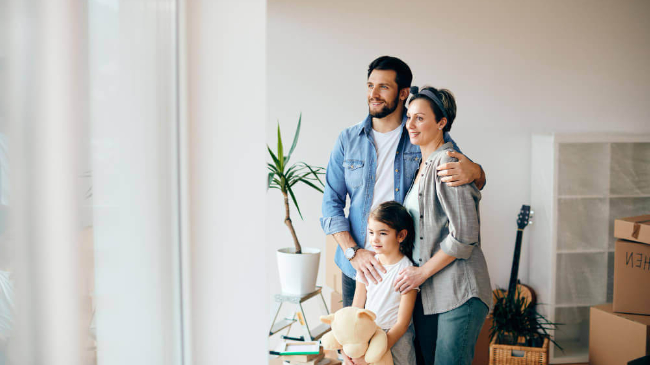 happy-family-looking-through-window-while-moving-into-new-home (1) (1)