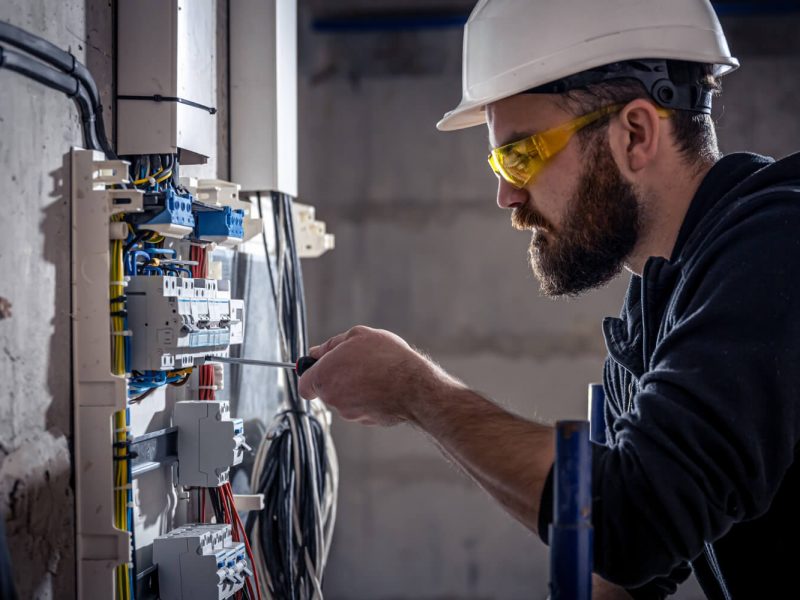 male-electrician-works-switchboard-with-electrical-connecting-cable (1)